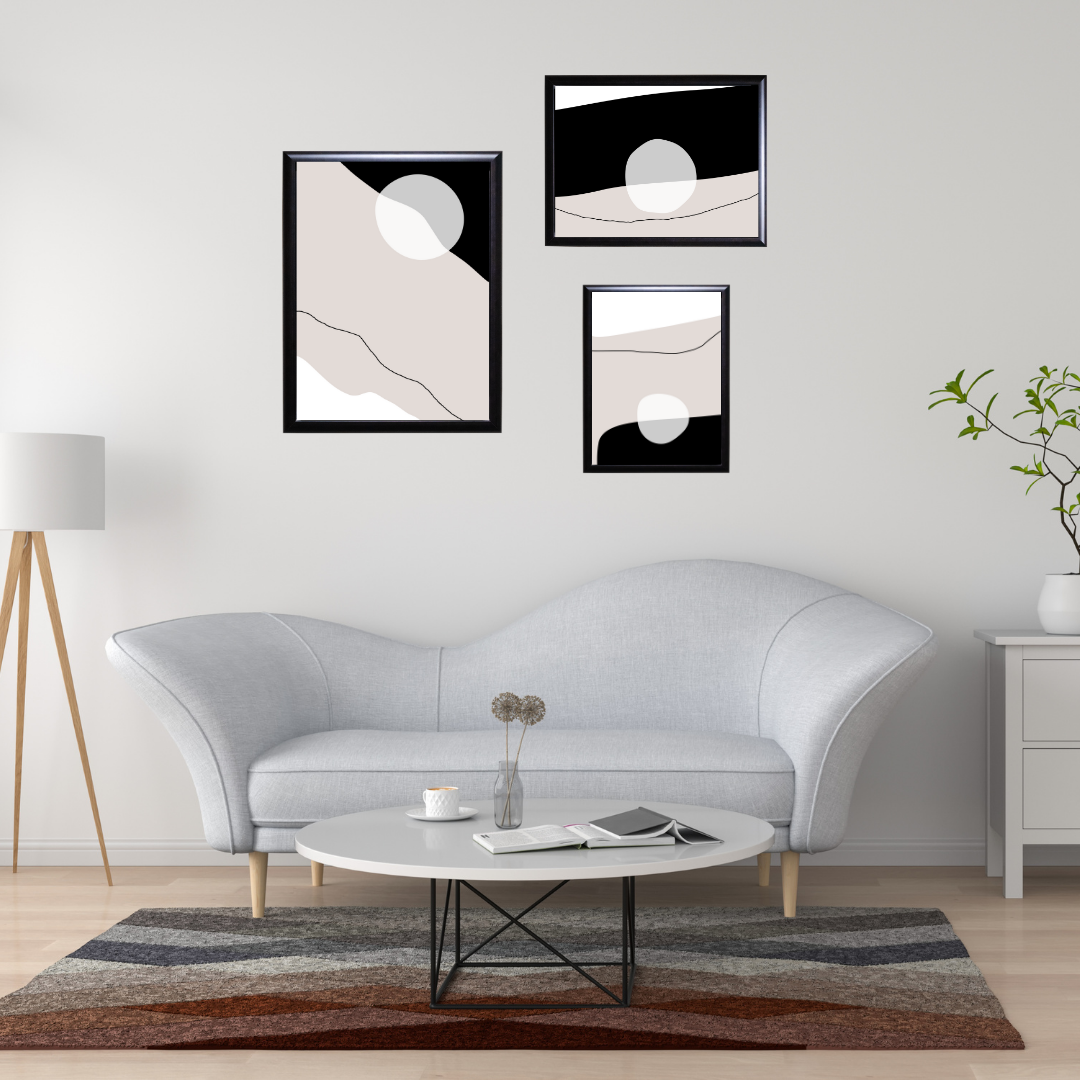 Printable abstract shapes in beige and black hanging in a modern living room.