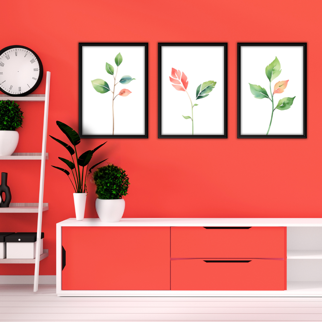 Watercolor botanical print with green leaves and red touches styled against a bright red wall in a modern setting.