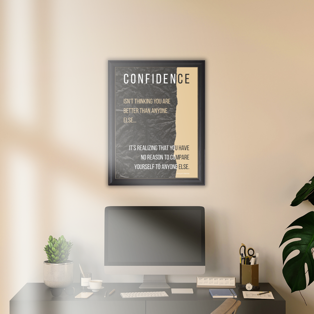 Confidence quote print above black desk and houseplant in a minimalist home study workspace.