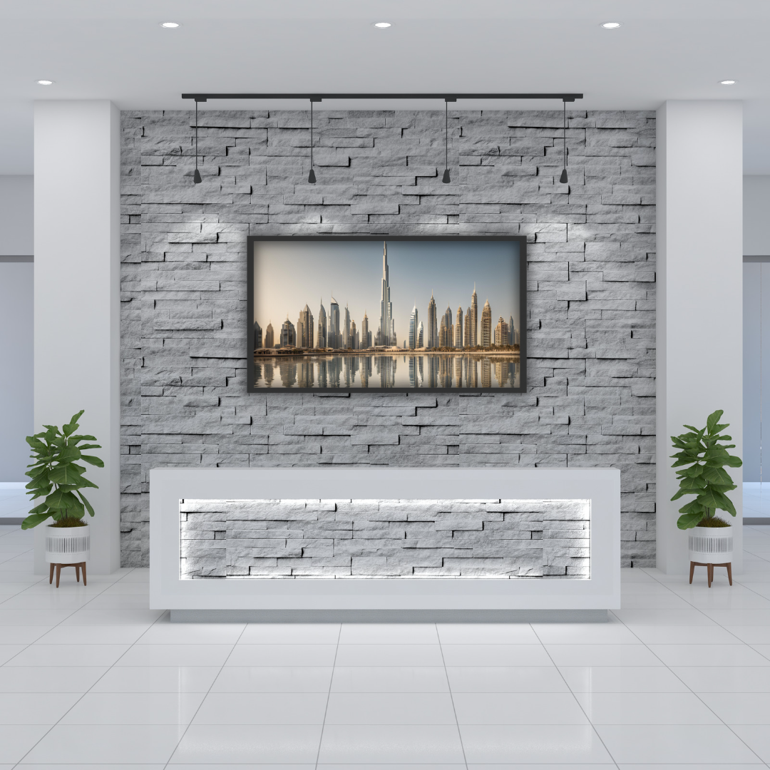 Elegant Dubai skyline print hanging above a reception area in a corporate office lobby, with modern brick decor.