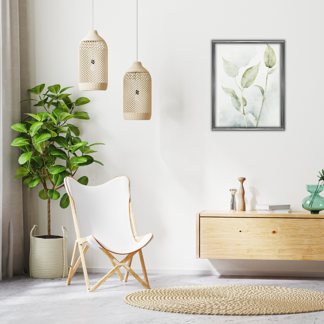 Framed botanical print with neutral tones of faded green and smokey beige in a minimalist setting with rattan decor.