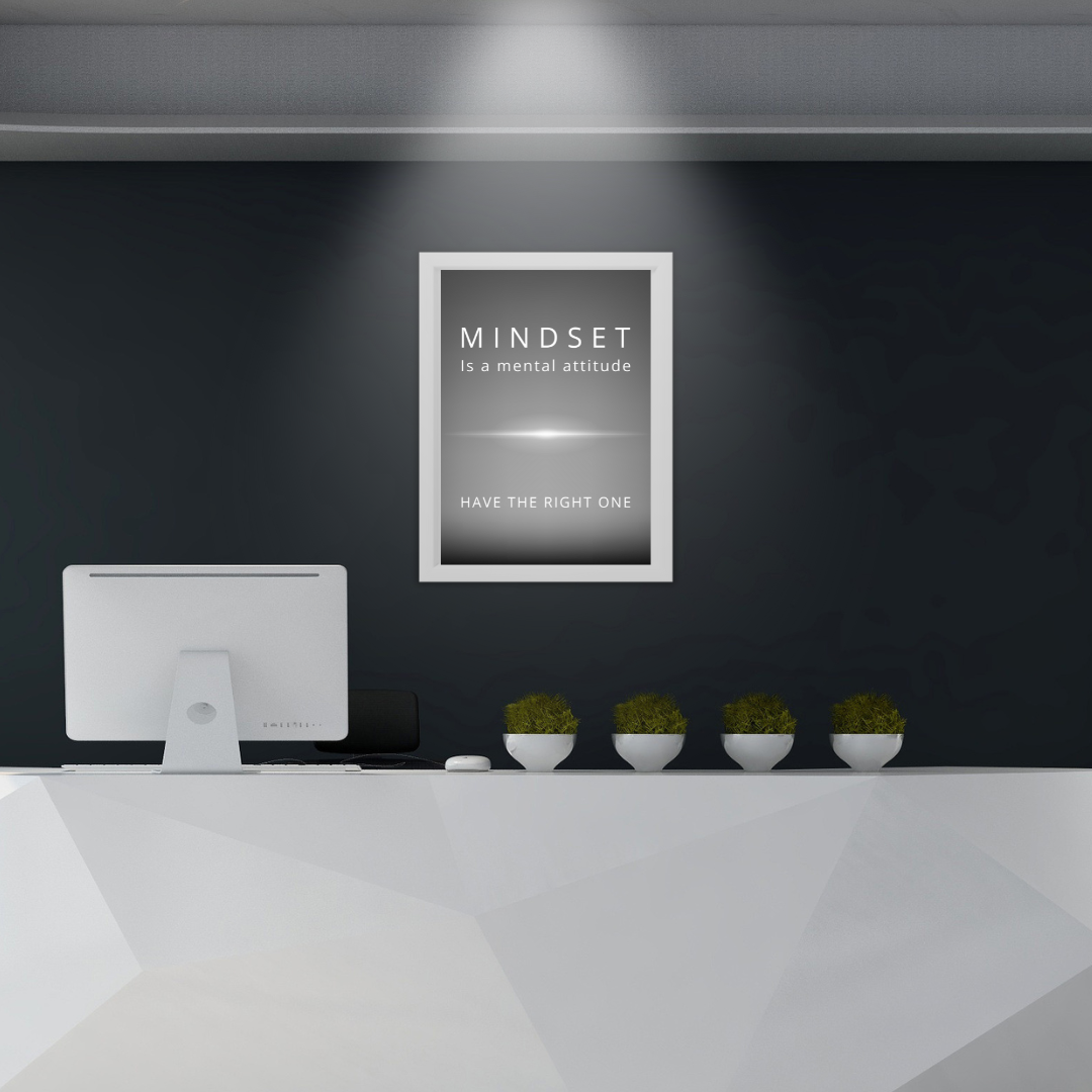 Framed motivational print in an office reception area with modern decor.