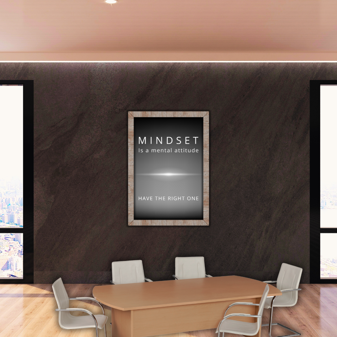 Large framed print of mindset quote in a well-lit corporate conference room.