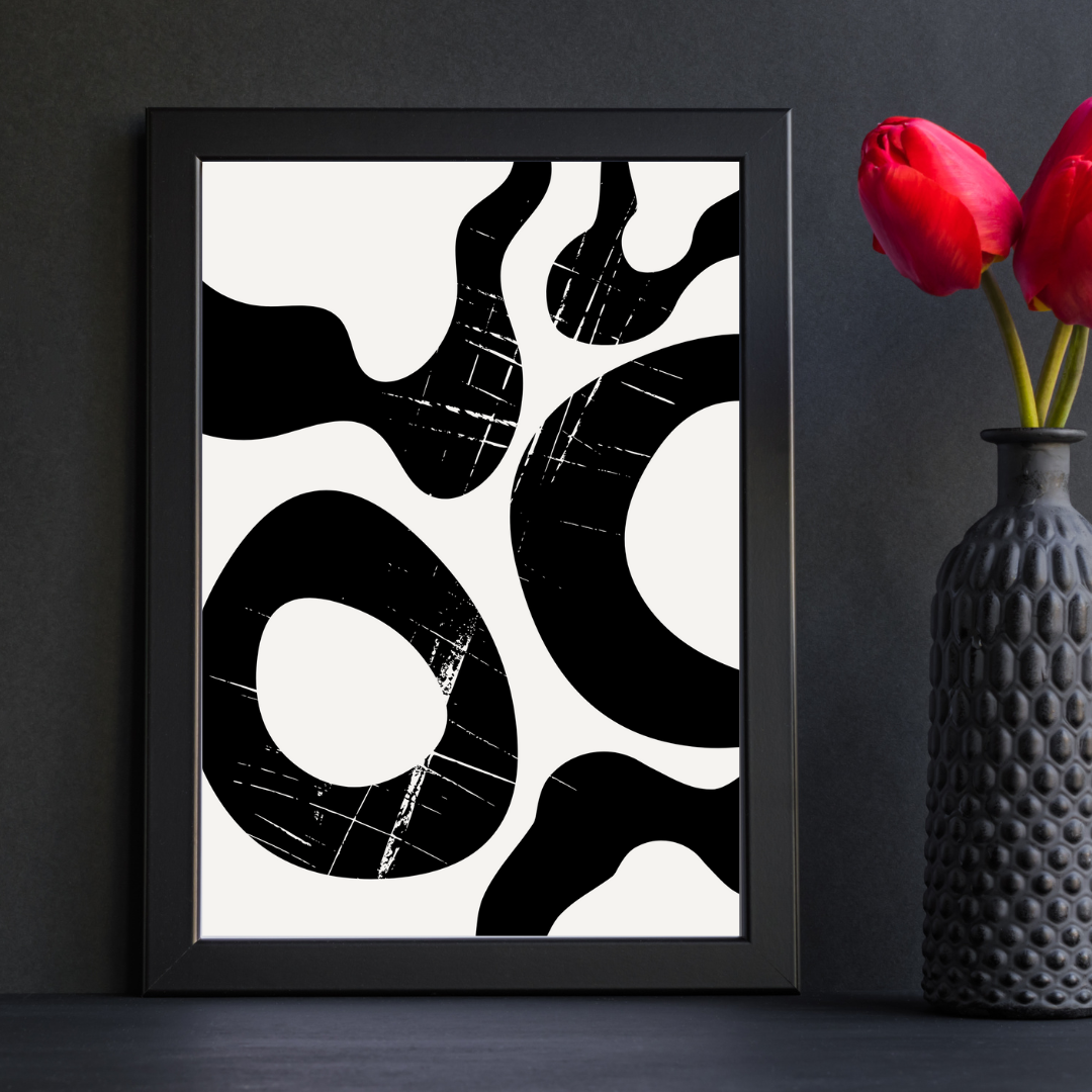 Framed abstract black and cream artwork on a dark wall with a textured vase and red tulips.