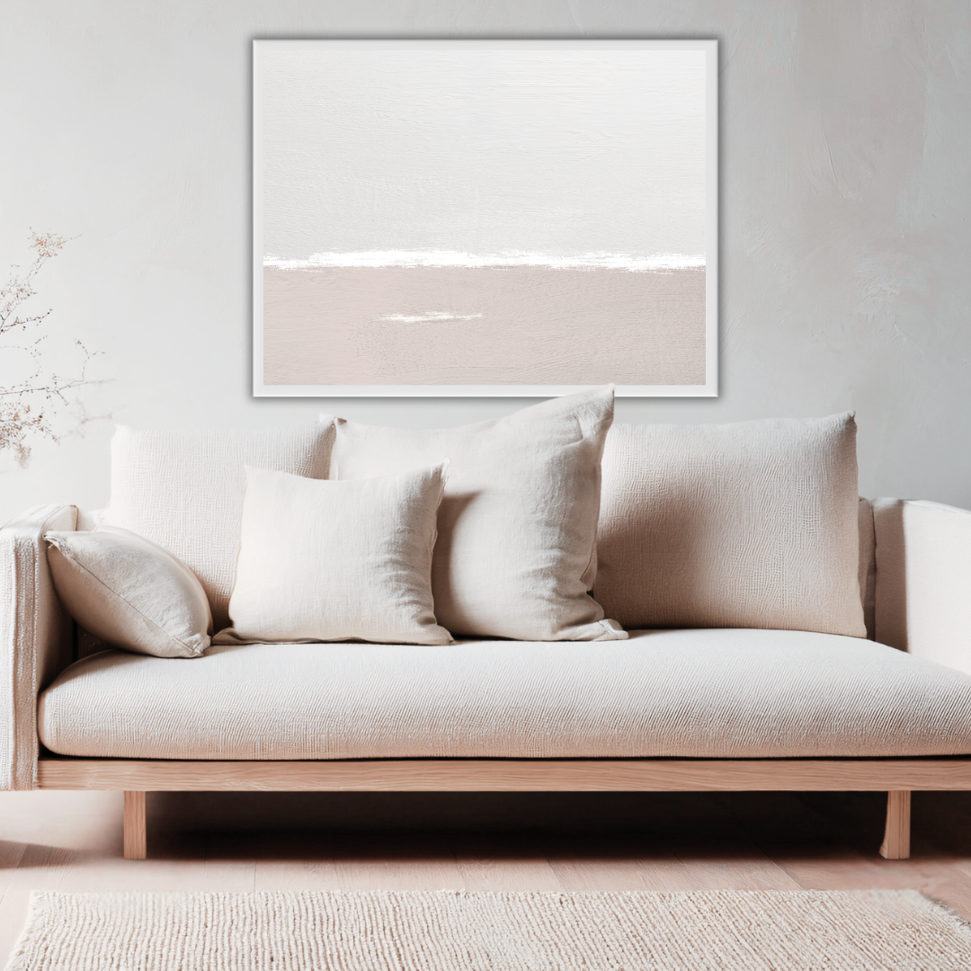 Beige sofa with decorative pillows in a coastal style living room setting with a Wabi Sabi sea and sky wall art framed on a neutral wall.