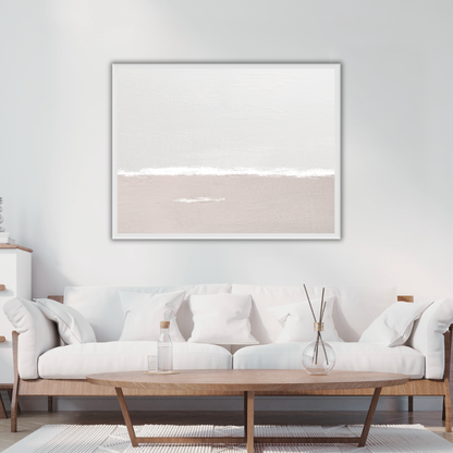 Framed sea and sky abstract art piece on a wall above a white sofa in a coastal inspired living room.