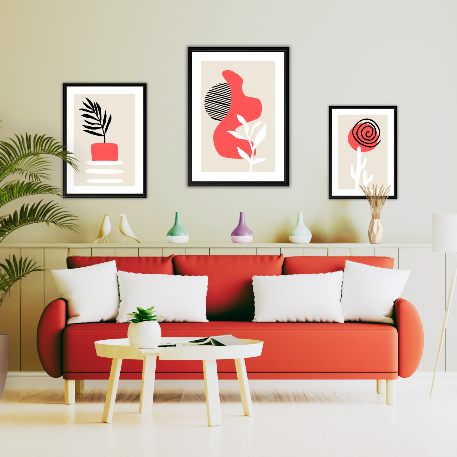 Set of three boho wall art prints with coral, black and white shapes on a neutral wall above a couch.