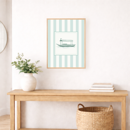 Framed artwork with an abra boat illustration on a striped background above a wooden console table.