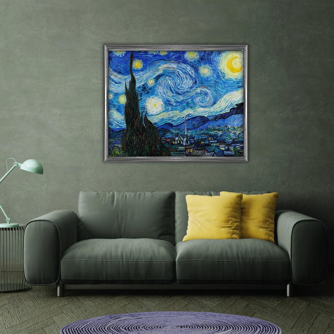 Framed Van Gogh Starry Night print above a grey velvet sofa in a modern living room with a touch of yellow decor.