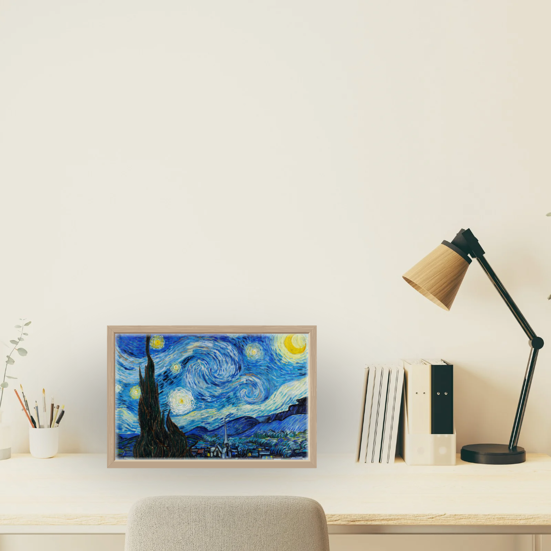 Vincent van Gogh Starry Night print displayed in a sleek home office on a light wood desk.