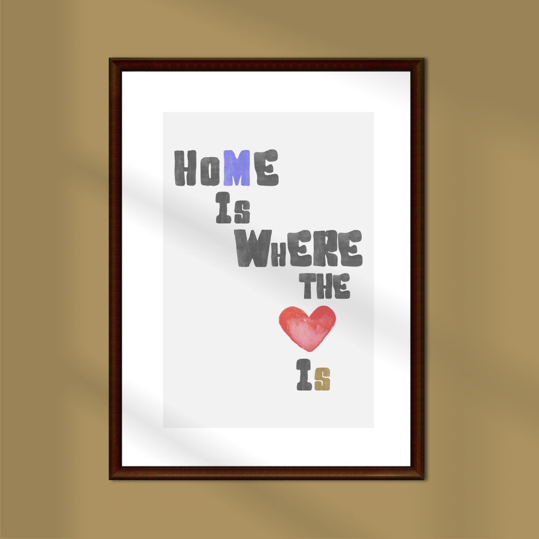 Framed poster with 'Home is where the heart is' text on a gold background.