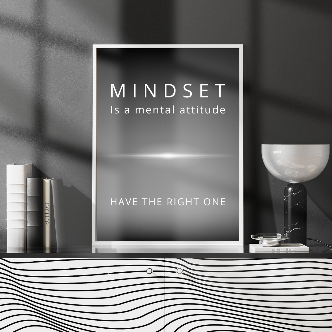 Framed “Mindset” print on a console table with books and a lamp in a modern reading nook.