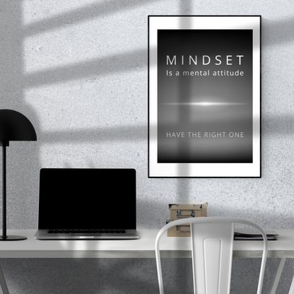Monochrome quote artwork on the wall above a minimalist home study desk with a laptop and a lamp.