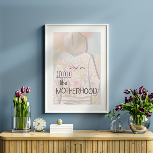 Floral motherhood quote print on a reading console beside vase of tulips and books.