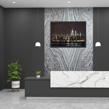 Reception area with a marble backdrop and counter and New York skyline wall art under soft lighting.