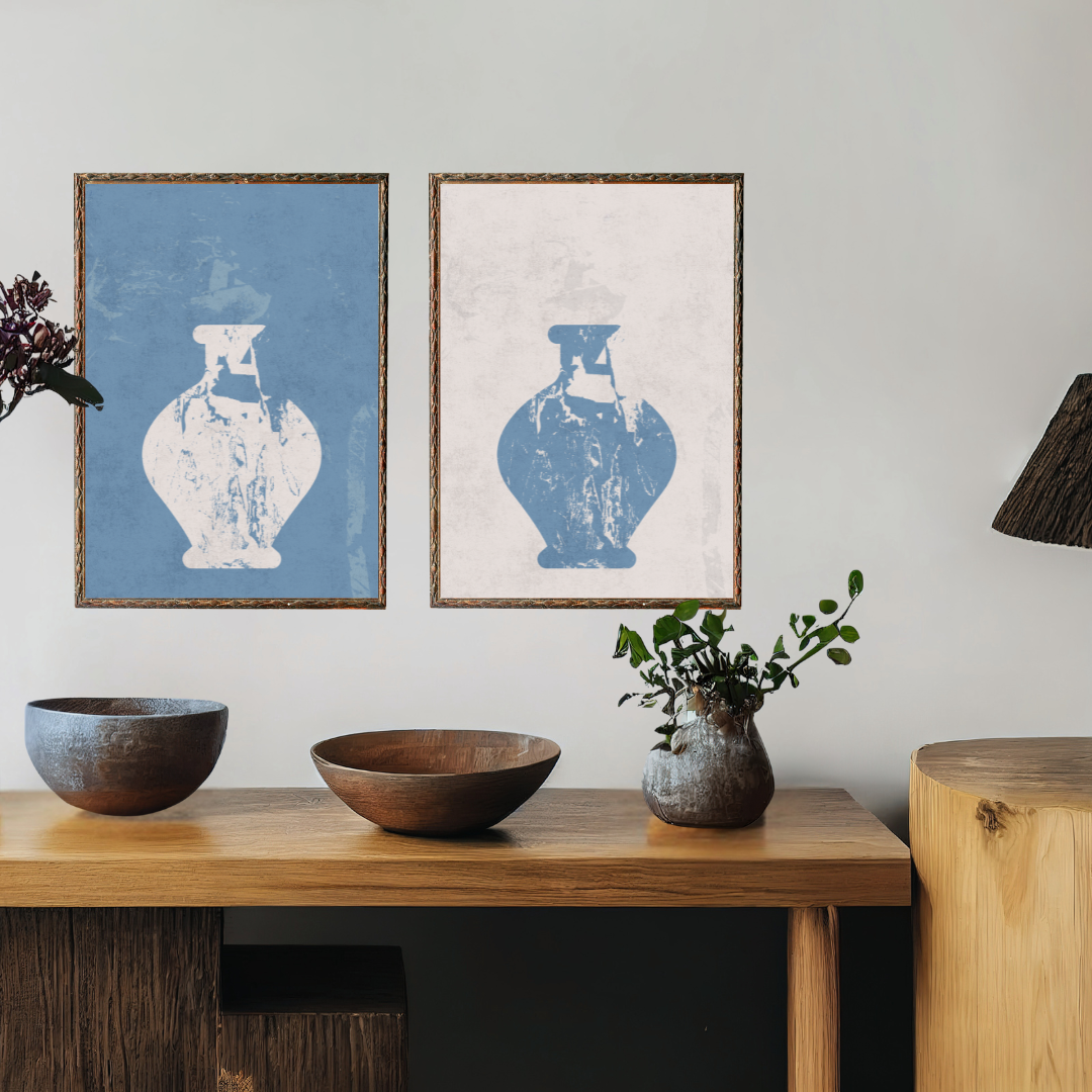 Two framed prints of vases on a wall above a wooden console table with decorative items.
