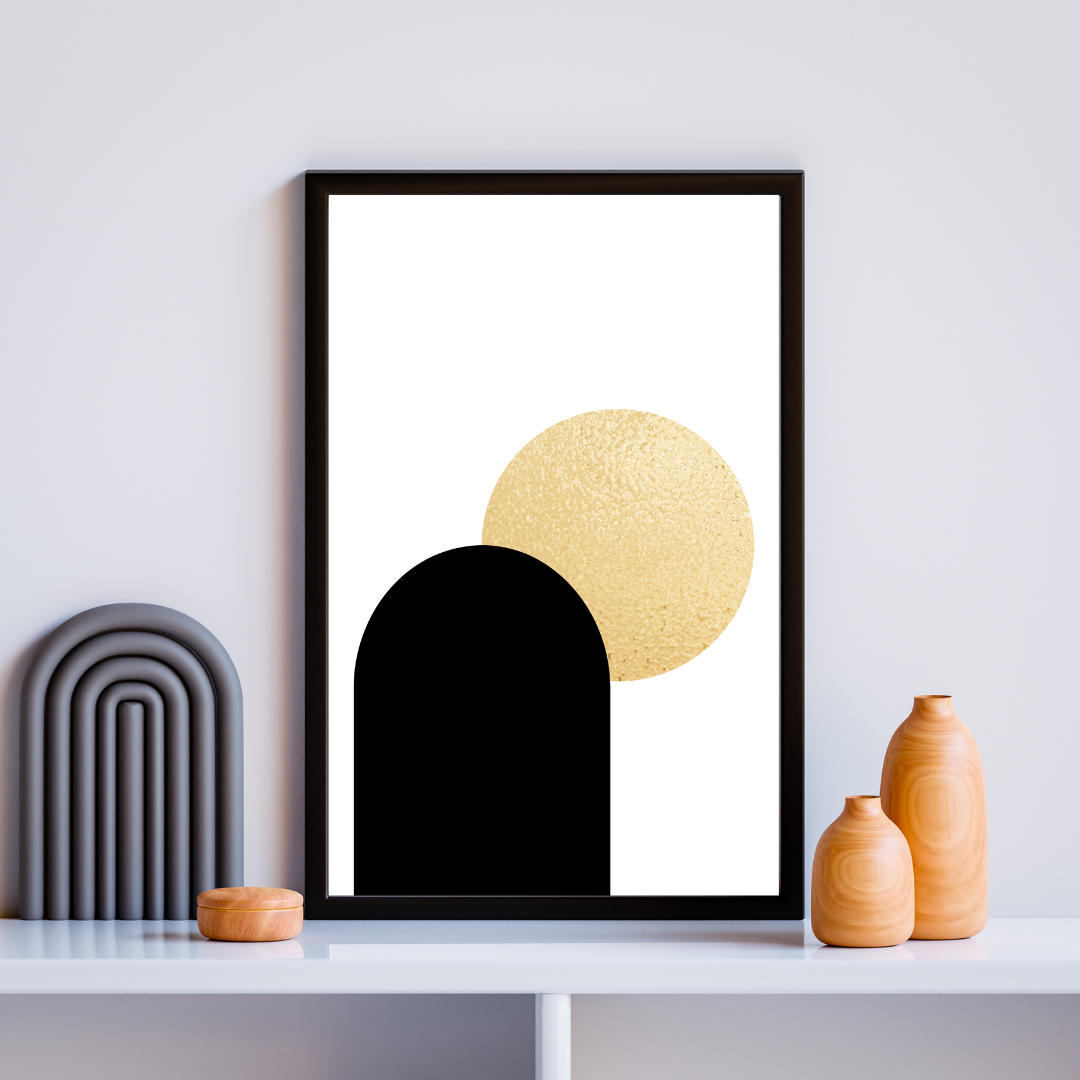 Framed boho style abstract art print with black and gold shapes on a white wall and boho decor.