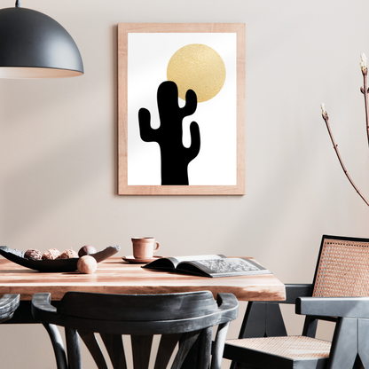 Dining room with a wooden table, chairs, and a framed artwork of a black cactus and gold sun on the wall.