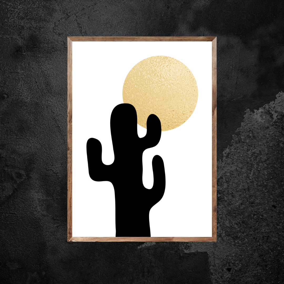 Framed boho artwork with a black cactus silhouette and gold shiny sun on a white background against a black backdrop.