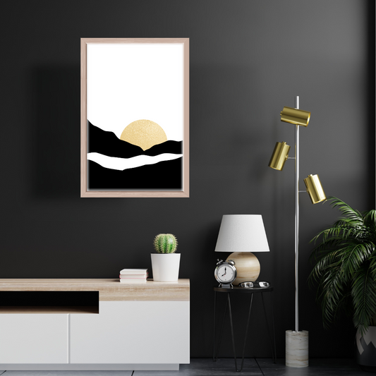 Modern interior with a framed boho black and gold sunset artwork mounted on a dark wall, with a gold lamp, and a potted cactus on a wooden console.