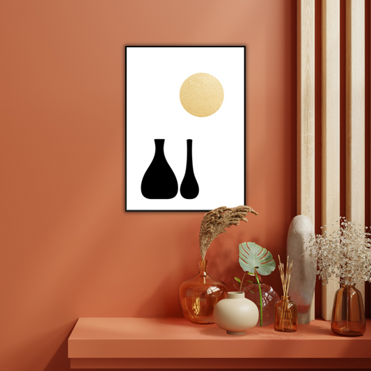 Framed abstract art with black vases and a golden sun mounted on a terracotta wall with decorative vases below.