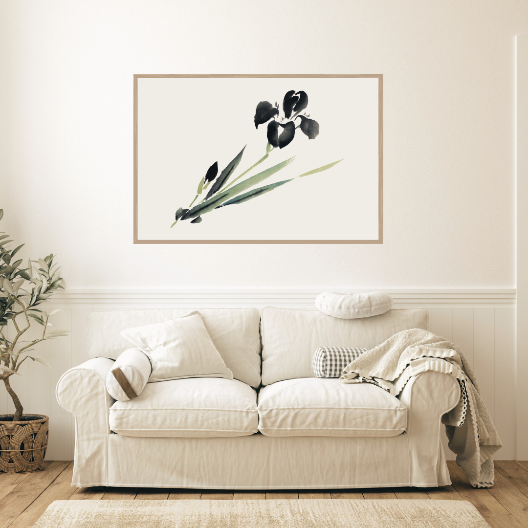 White sofa in a living room with a framed Japanese ink botanical print on the wall.