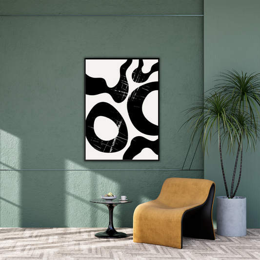 Abstract Japandi artwork with black and cream shaped framed on a sage green wall with a modern chair, a side table and plant.