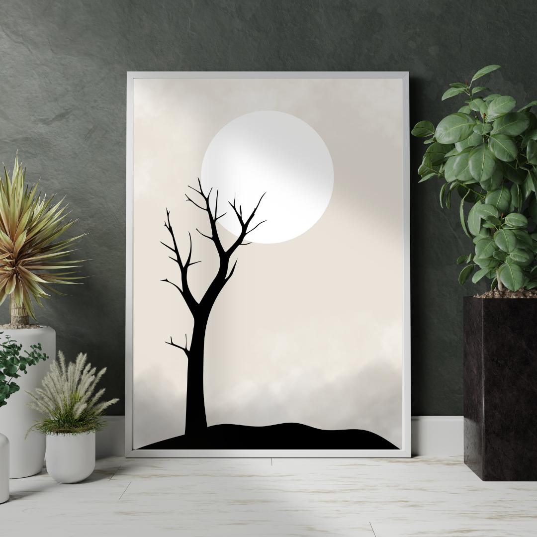 Framed artwork of a black tree silhouette against a neutral background with a full moon, placed on a wooden floor with decorative plants.