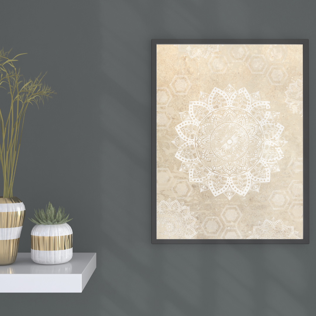 Framed neutral mandala art on a dark grey wall with decorative plants sitting on a white shelf below.