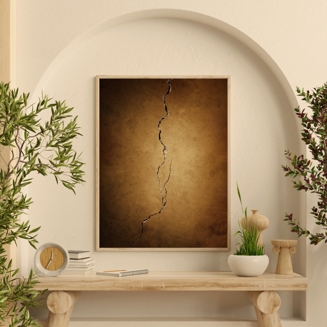 Framed Kintsugi artwork with a natural theme on a wooden shelf against a beige wall.