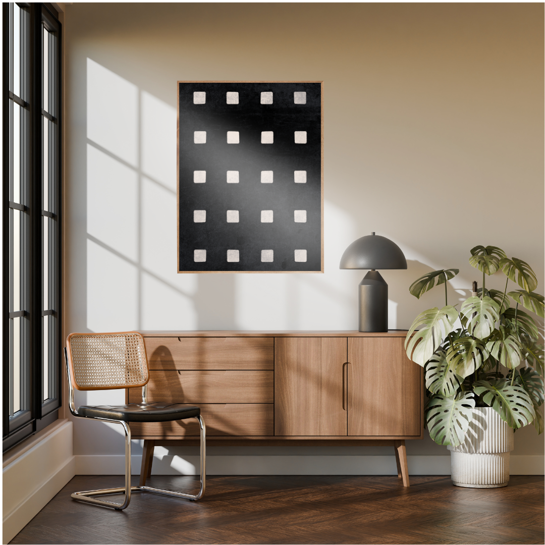 Modern interior with a Wabi Sabi geometric artwork of ivory squares framed above a wooden cabinet, chair, and a decorative plant.